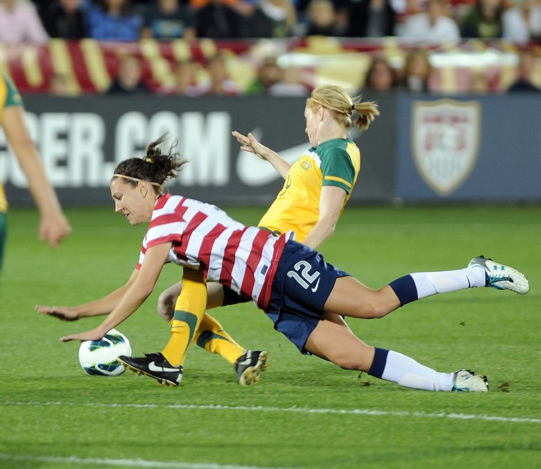 USA's Lauren Cheney (12) gets tripped up by Australia's Clare Polkinghorne during the first half of an international friendly match Sept. 19, 2023, at Dick's Sporting Goods Park in Commerce City.