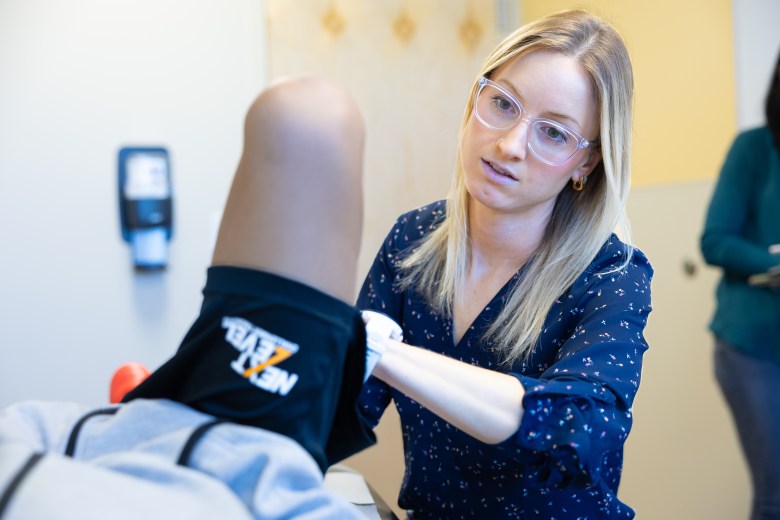 A female physican looking at an athletes knee
