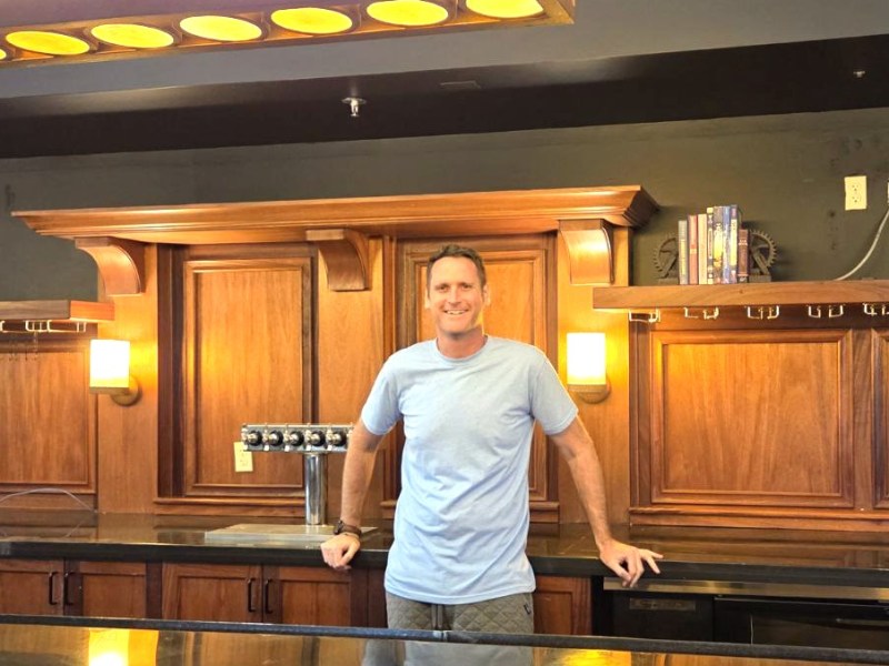 man leaning against a bar