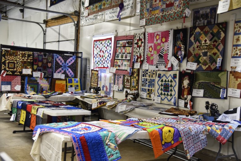 A wall of homemade quilts.