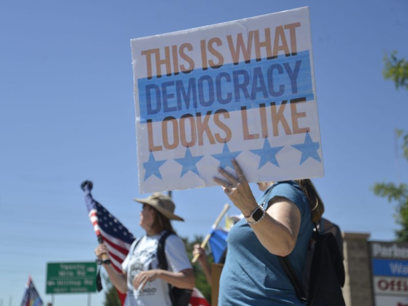 A woman holds a sign that says "This is what democracy looks like."