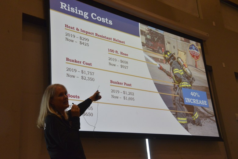 A woman points at a screen during a presentation.