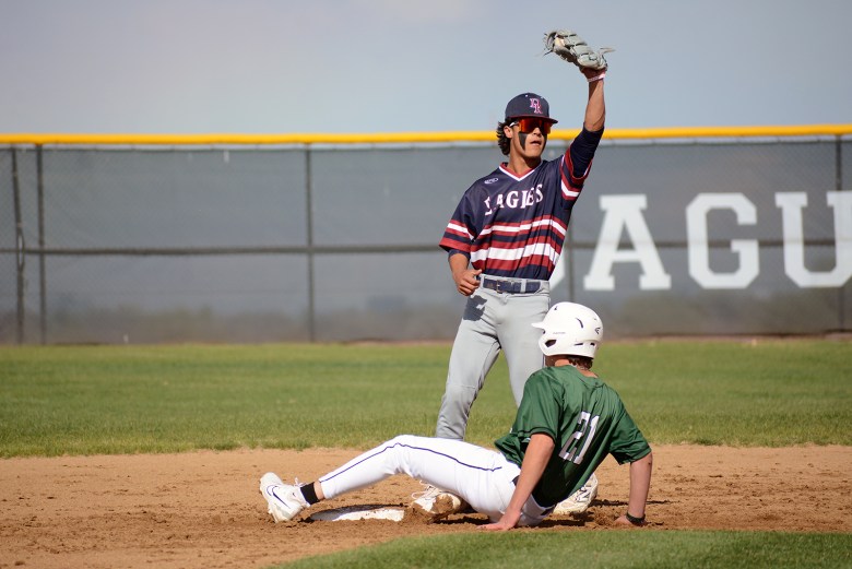 Dakota Ridge junior Breckin Maynes tags out D'Evelyn freshman Leo Vigil (21) on a steal attempt on Thursday, May 1, at D'Evelyn Junior/Senior High School. Dakota Ridge scored seven runs in the top of the fifth inning on the way to an 11-1 victory.