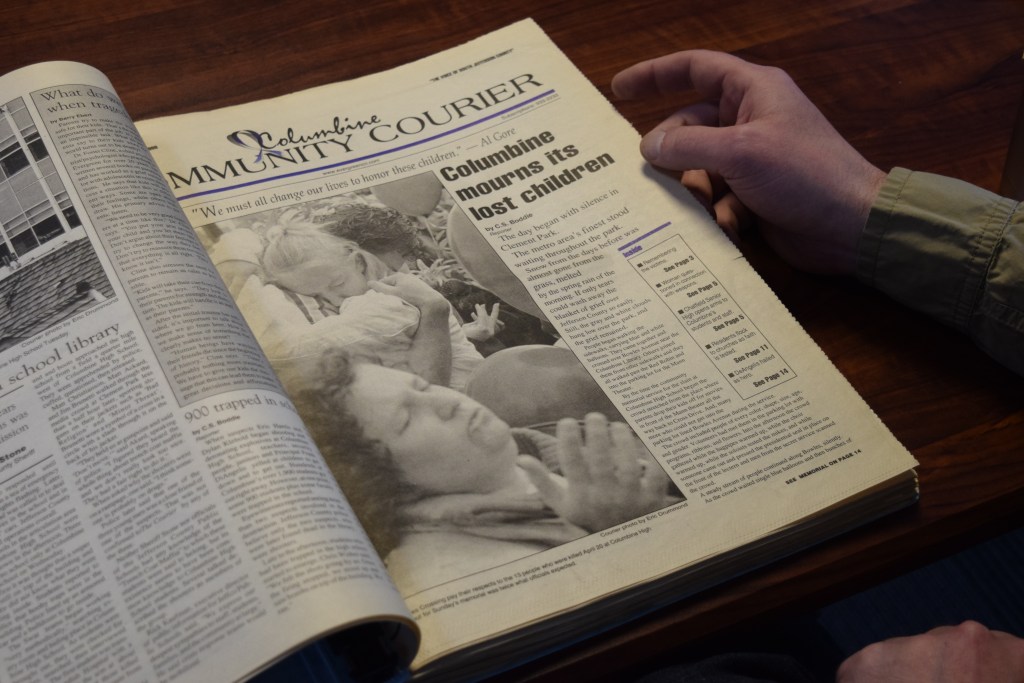 A newspaper archive book open to a page about the mass shooting at Columbine High School in 1999