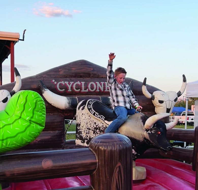 A young buckaroo enjoys the mechanical bull at Cowboy Up in Kiowa.