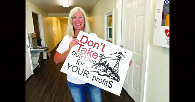 Elbert County Environmental Alliance board member Kerry Jiblits holds a protest sign at the county commissioners' public hearing on Xcel Energy's Colorado Power Pathway plan.
