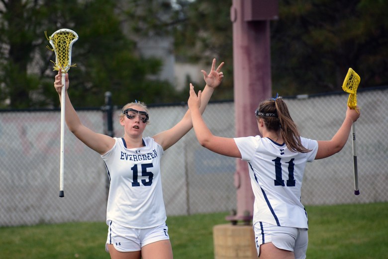 Evergreen senior Addison McEvers (15) and junior Ryn Gardner (11) celebrate a Cougar goal during the Class 4A girls lacrosse state championship game on Friday, May 16, at Peter Barton Stadium. Evergreen defeated Green Mountain 19-6 to claim back-to-back state titles.