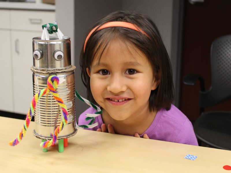 Adalie Gonzalet Prehn, 5, smiles with her completed robot statue and her new Bristlebot, which is on top of the statue, during a March 27 event at the Golden Library.