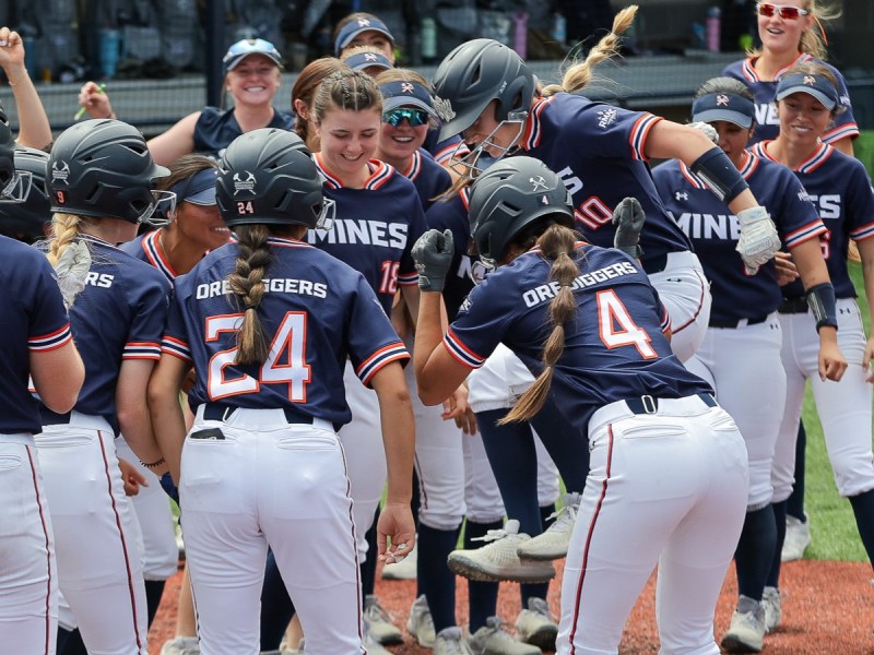 Colorado School of Mines senior Cassidy Chvatal (10) celebrates scoring a home run with her teammates