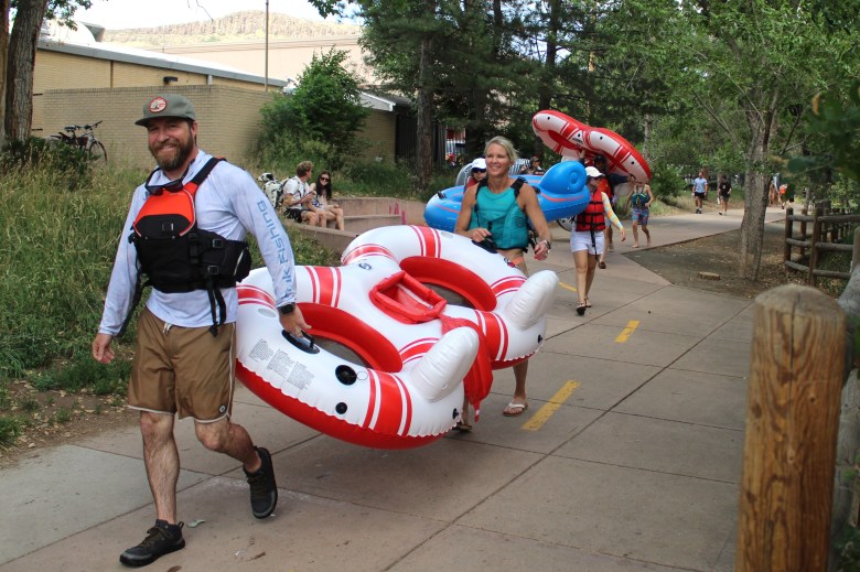 On June 28, people carry innertubes as they walk along the north Clear Creek Trail past Golden City Hall.