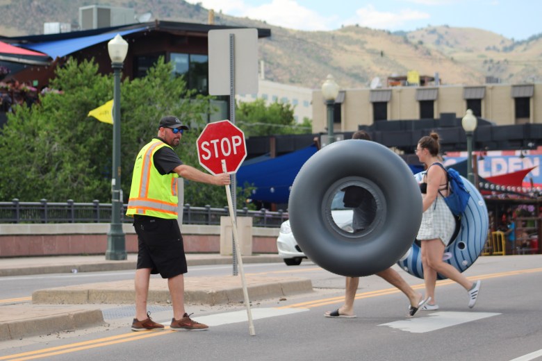 On June 28, a City of Golden flagger stops motor vehicle traffic to allow tubers to cross Ford Street near the Golden Mill