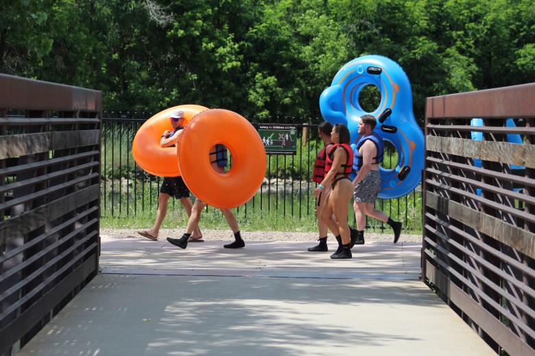 A group of tubers walk along the Clear Creek Trail near U.S. Highway 6.