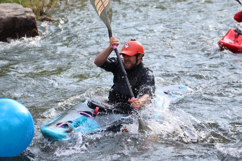 A member of Team H2O tries to get the yoga ball toward the finish line during the July 10 downriver race at the Clear Creek Whitewater Park.