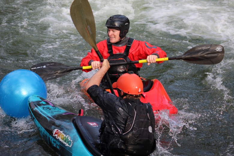 Members of Team H2O try to hit their yoga ball across the finish line during the July 10 downriver race at the Clear Creek Whitewater Park.
