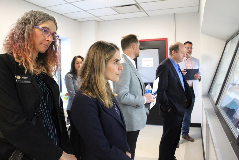State Rep. Brianna Titone, far left, and other officials survey the new CoorsTek Academy Training Center from an overhead observation deck