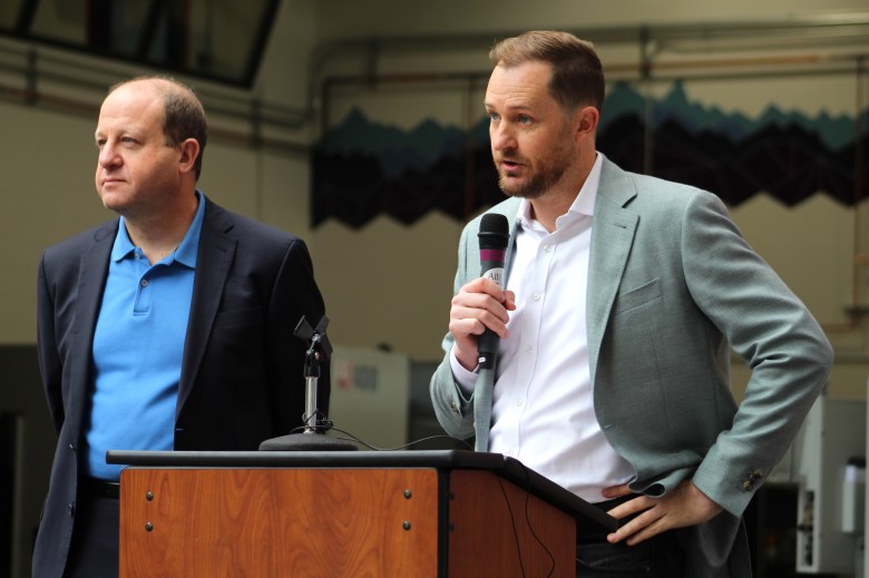 Colorado Gov. Jared Polis, left, and CoorsTek CEO Michael Coors speak at the July 16 ribbon-cutting ceremony for the CoorsTek Academy Training Center.