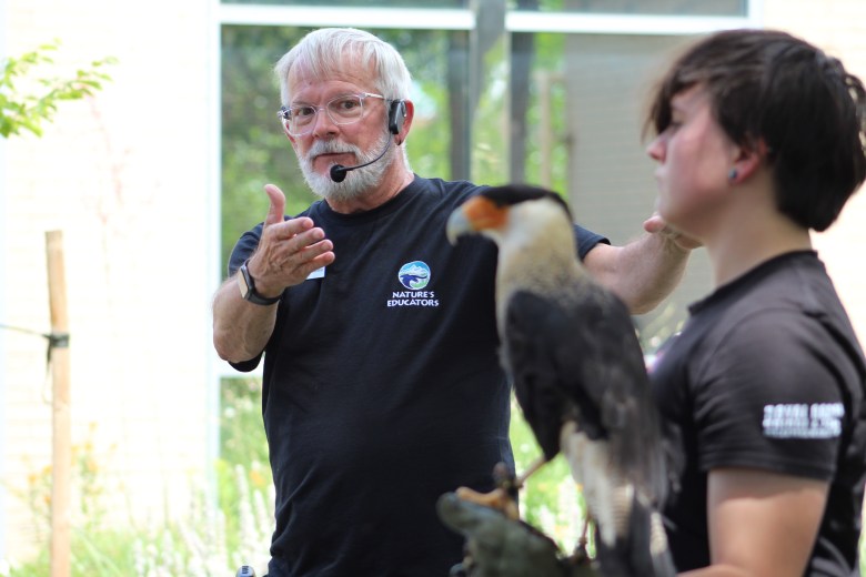 At left, Nature's Educator program specialist Alex Olow talks about Salvador the crested caracara, who's being held by Nature's Educator volunteer Kade Rodenbeck, at right.