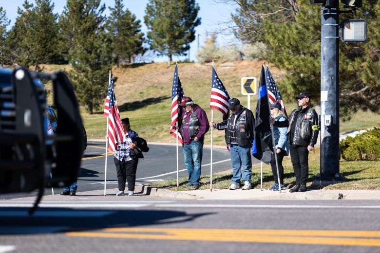 Standing along the road to Mission Hills Church Nov. 13, supporters bow their heads as Golden Police Officer Evan Dunn's funeral procession makes its way past.