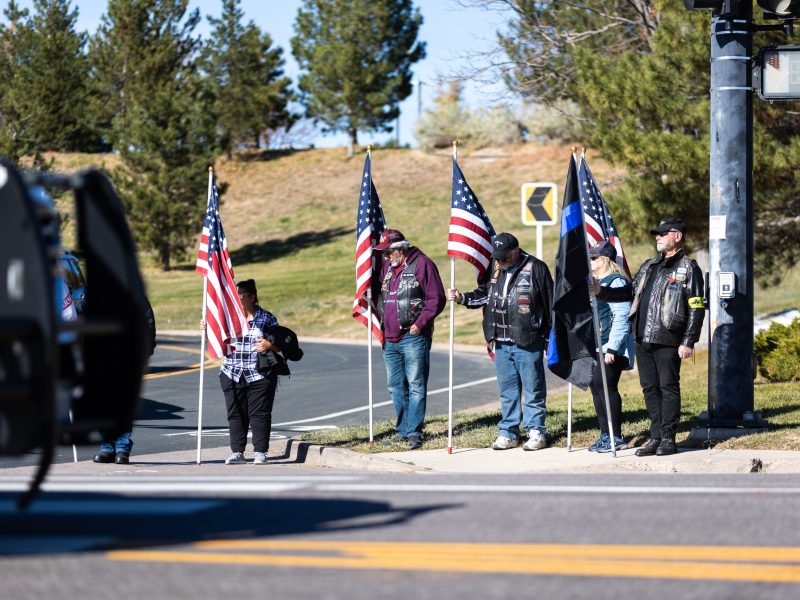 Standing along the road to Mission Hills Church Nov. 13, supporters bow their heads as Golden Police Officer Evan Dunn's funeral procession makes its way past.