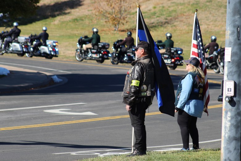On Nov. 13, Golden firefighters stand atop their new aerial ladder truck after Golden Police Officer Evan Dunn's funeral procession passes along County Line Road to Mission Hills Church.