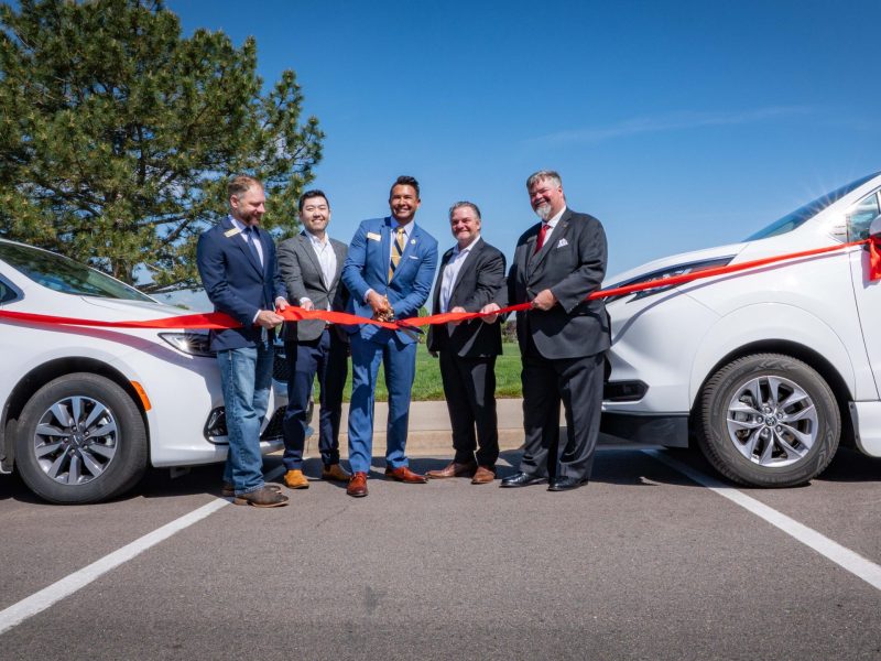 A group of elected officials cut a ribbon at an opening ceremony.
