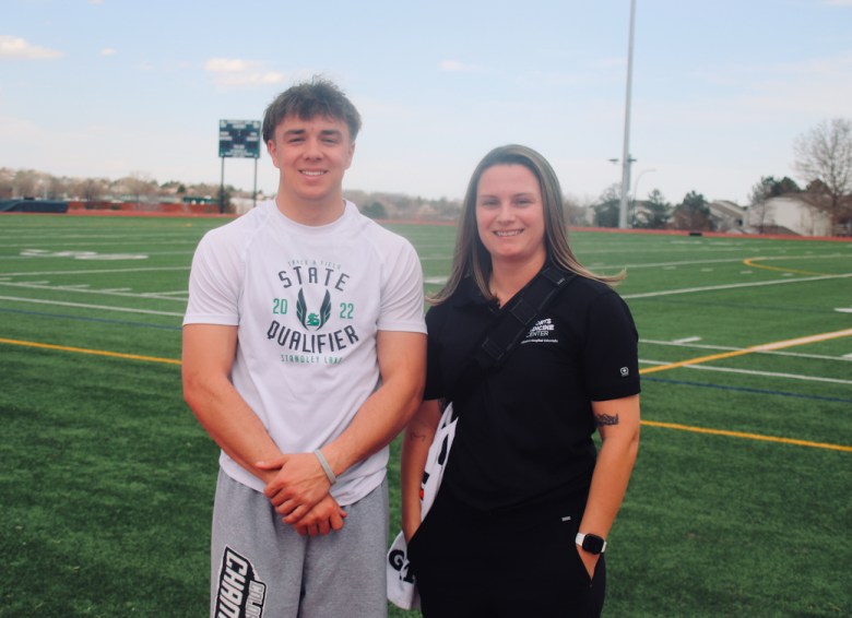 Standley Lake senior Liam Graham and athletic trainer Mercedes Steidley pose for a photo at the Gators' football field. Graham is a multi-sport athlete in football and track, and is back on the field after several years of health issues Steidley helped discover.