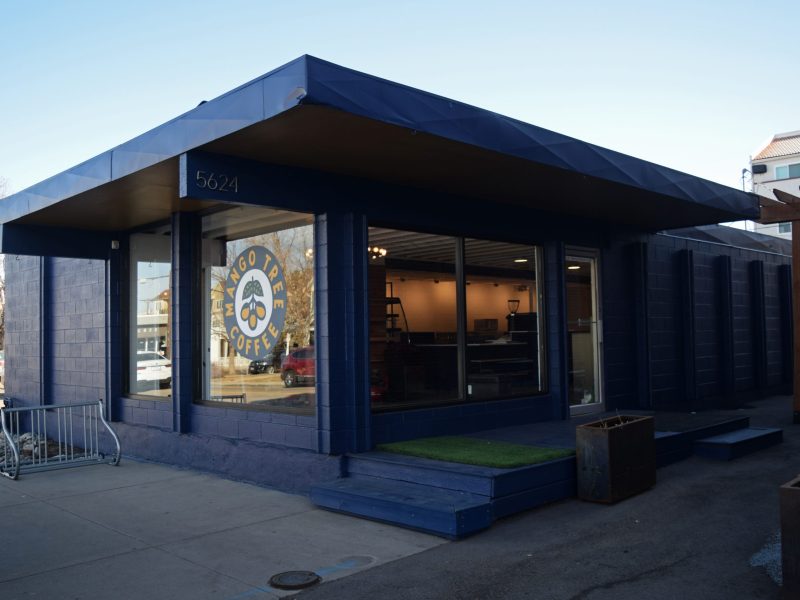 a building with a logo on the window that says "mango tree coffee"