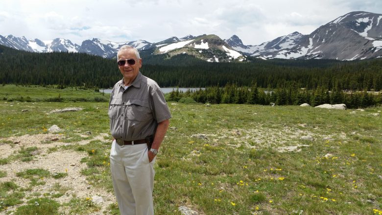a man stands in front of mountains