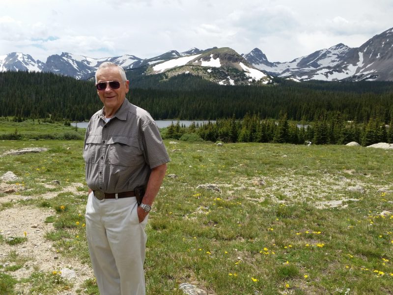a man stands in front of mountains