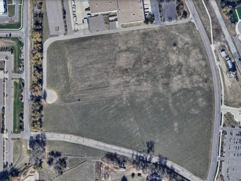 Aerial image from Google Earth showing a large undeveloped 13.5-acre field in Thornton, Colorado, bordered by roads and parking lots. RTD’s Eastlake/124th light rail station is visible in the lower right corner.