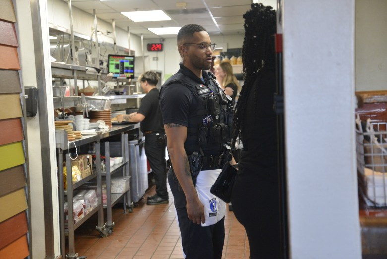 A police officer stands in a Chili's kitchen.
