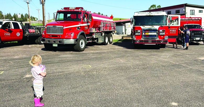 A little girl looks in wonder at the Elizabeth Fire Protection District fleet.