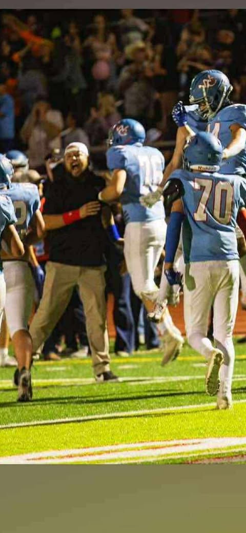 Weld Central's new head football coach, Travis Letkomiller (left) celebrates a play with other Rebels' players.
