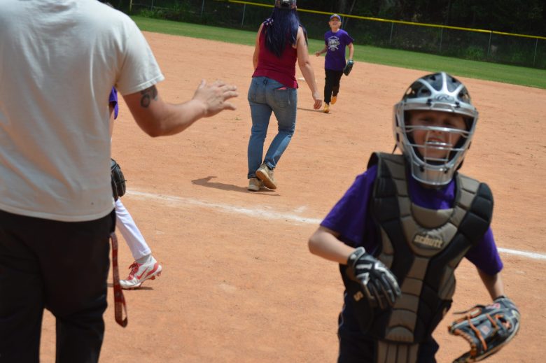 Teams take a break between innings in the Gilpin versus Clear Creek Unicorns game in Idaho Springs on June 28.