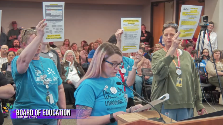 Tiffany LoSasso speaks at a podium during a Jefferson County Board of Education meeting, with librarians behind her holding printed and highlighted library policy documents in protest.